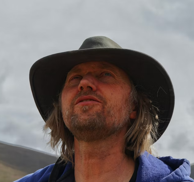 Middle-aged man in hat looking up