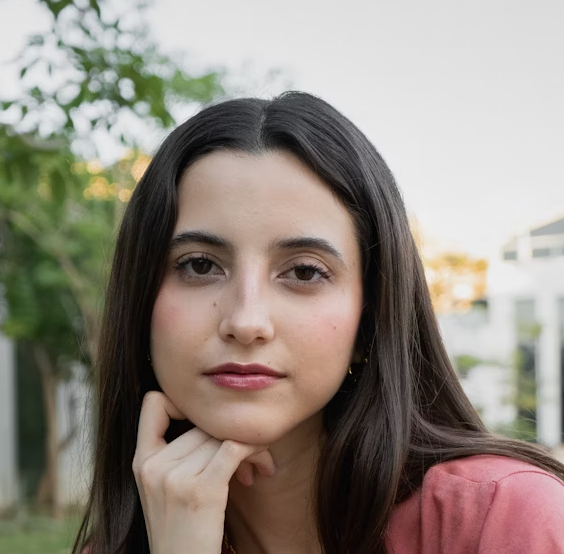 Young woman resting chin on hand, looking calm